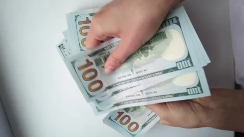Top view of person counting stack of hundred dollar bills on white backgrou.. Stock Footage 339374868
