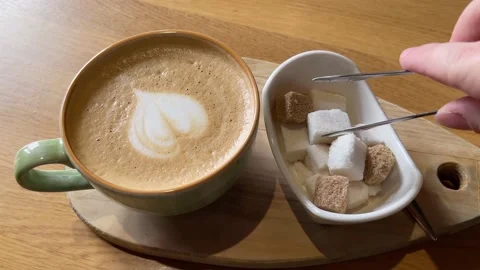 Top view of person hand puts a lump of sugar in the coffee. Stock Footage 236843309