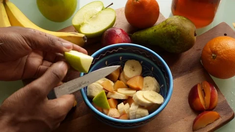 Top view person making healthy fruit salad at home- 15s Stock Footage 128778992