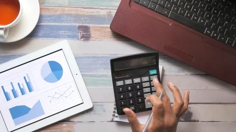 Top view of a person performing cost analysis at a desk with a digital tabl.. Stock Footage 333031420