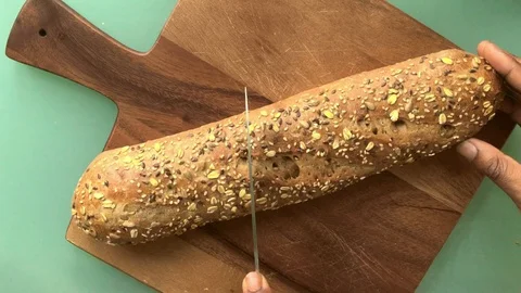 Top view person slicing bread on wooden board - 25 s 스톡 동영상 128016899