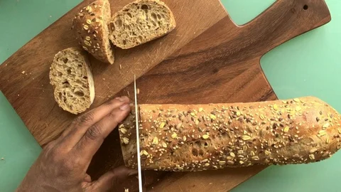 Top view person slicing bread on wooden board - 25s 스톡 동영상 128016946