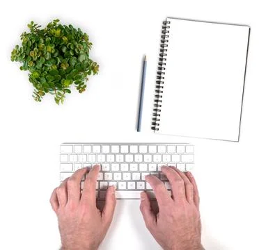Top view of person typing on wireless computer keyboard on white desk with Stock Photos