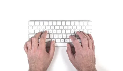 Top view of person typing on wireless computer keyboard on white desk Stock Photos