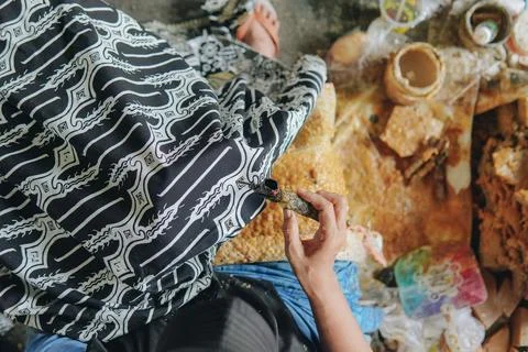 Top view of a person's hand drawing the design pattern of Indonesian batik .. Stock Photos