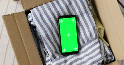 Top view of phone green screen mockup in box with used clothes. Stock Footage 155075127