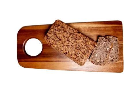 This top-view photograph features a rustic seed and nut bread loaf with a cut Stock Photos