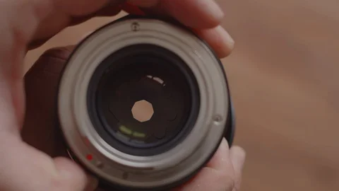 Top view of the photographer's hands checking the lens opening and closing the Stock Footage 127665323