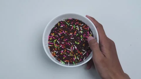 Top view of picking up and putting down a bowl of chocolate sprinkles Stock Footage 280452736