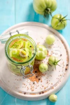 Top view of pickled green tomatoes in the jar Stock Photos
