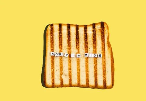 Top view piece of bread toasted in toaster with inscription acrylamide. Con.. Stock Photos