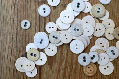 Top view of a pile of small circle buttons on a wooden surface Stock Photos