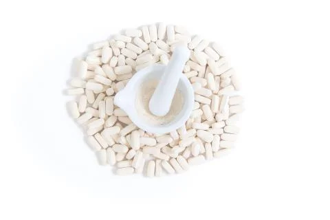 Top view of pile of white tablets with a mortar and pestle Stock Photos