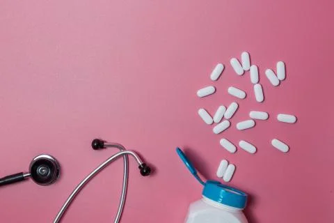 Top view of pills in bottle pack, stethoscope on blue background Stock Photos