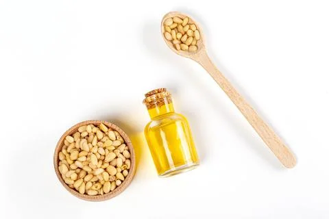 Top view, pine nut oil in bottle with pine nuts in wooden spoon and bowl Stock Photos