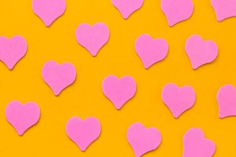 Top view pink hearts pattern on a vibrant yellow background Stock Photos