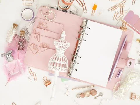 Top view of a pink planner with cute stationery. Pink glamour planner with a Illustrazione stock