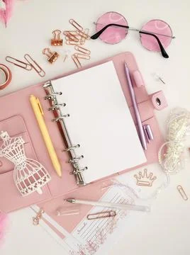 Top view of a pink planner with cute stationery. Pink glamour planner with a Illustrazione stock