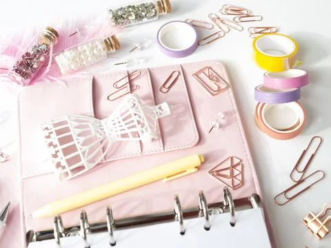 Top view of a pink planner with cute stationery. Pink glamour planner with a Illustrazione stock