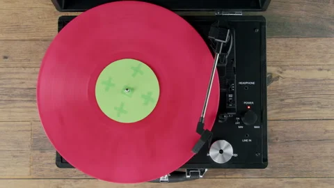 Top view of pink vinyl on Record player wooden table with green label Stock Footage 218629793