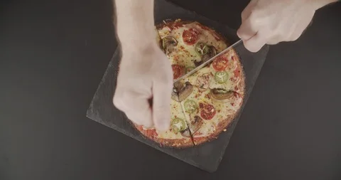 Top view pizza with tomatoes and mushrooms cut with sharp pizza knife into Stock Footage 123099793