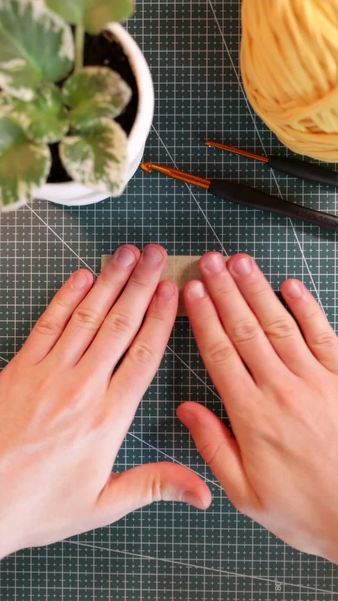 Top view of placing blank tape sticker near knitting yarn and flowerpot. Stock Footage 338183549