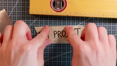 Top view of placing DIY PROJECT handwritten tape sticker on mat. Stock-Footage 337816293