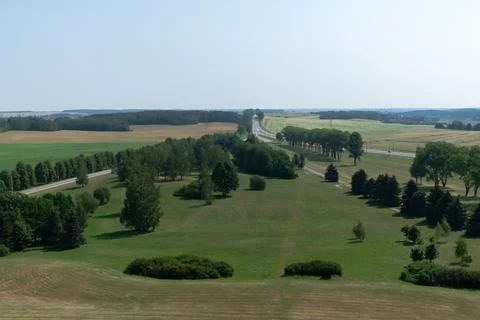 Top view of a plain with green meadows with parklands and a highway with pass 스톡 사진