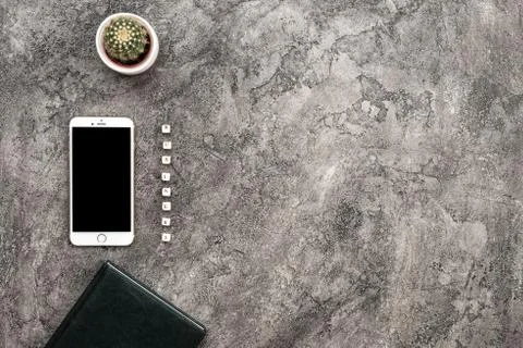 Top view plaster background with smartphone and cactus. Inscription businessm Stock Photos