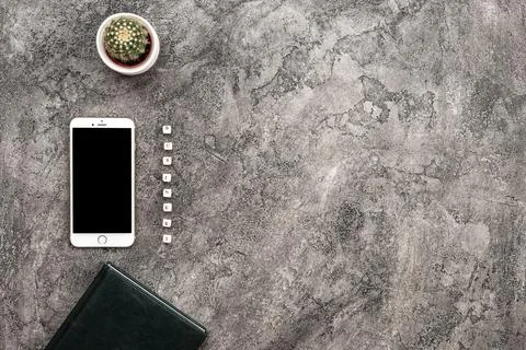 Top view plaster background with smartphone and cactus. Inscription busines.. Stock Photos