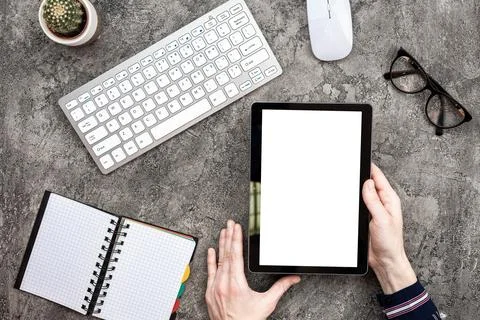 Top view plaster background with tablet in male hand. Keyboard, glasses and.. 스톡 사진