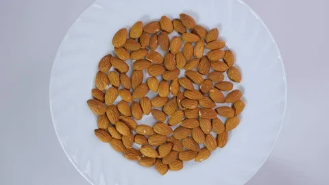 Top view plate with almonds rotating on a white background Stock Footage 105145876