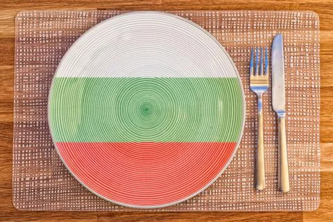 Top view of a plate with the flag of Brunei and silverware on a wooden table. Stock Illustration