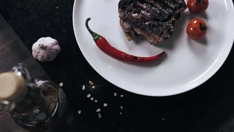 Top view on the plate with grilled veggies and a steak, peppering the dish Stock Footage 133029902