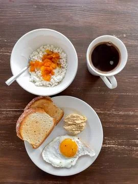 Top view of plate with toasted bread fried egg and hummus with cottage chee.. Stock Photos