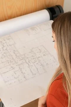 Top view of plotter printer printing floor plans by young beautiful woman 写真素材