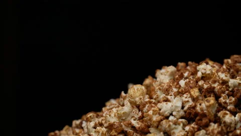 Top view of popcorn falling on rotating table full of corns in slow motion. Video stock 92830437