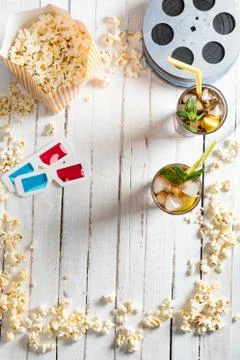 Top view of popcorn with iced tea, film reels and 3D glasses on table, Movi.. Stock Photos
