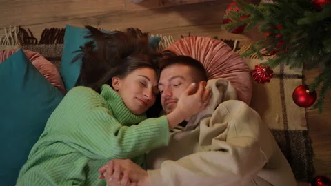 Top view portrait of loving young man and woman hugging lying at Christmas tree Video stock 219910058