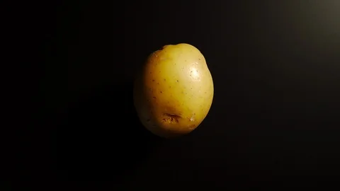 TOP VIEW: Potato rotates on a black surface - Stop motion Vídeo Stock 100258197