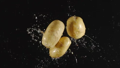 TOP VIEW: Potatoes fall in a water, splashing - Slow motion Vídeos de archivo 115319207