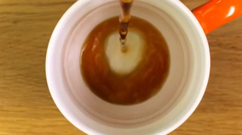 Top view of pouring black coffee into a mug against a wooden background Stock Footage 64310205