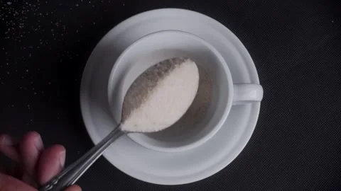 Top view pouring sugar with spoon into white mug cup Stock Footage 281638151