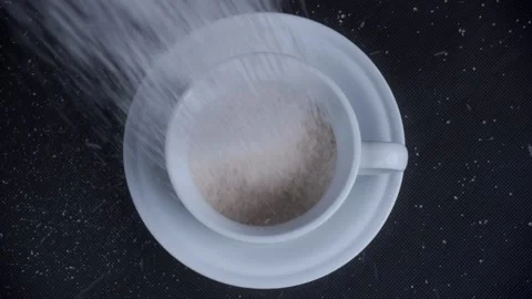 Top view pouring sugar into white mug cup on black background Stock Footage 281638697