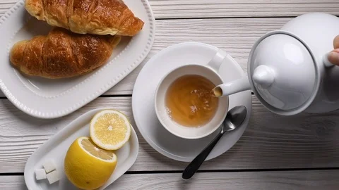 Top view of pouring tea on a cup - slow motion Video stock 129813503
