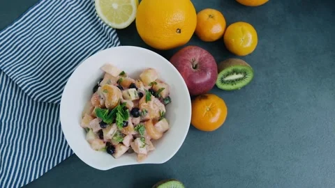 Top view on the prepared fruit salad with kiwi, oranges, apples, berries, sweet Video stock 136674468