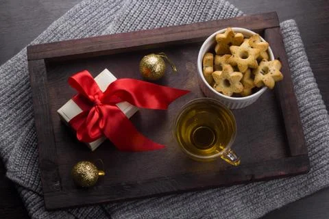Top view present with red bow, cookies in a shape of stars,tea cup  and golde Stock Photos