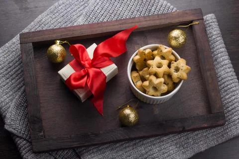 Top view present with red bow, cookies in a shape of stars and golden christm Stock Photos