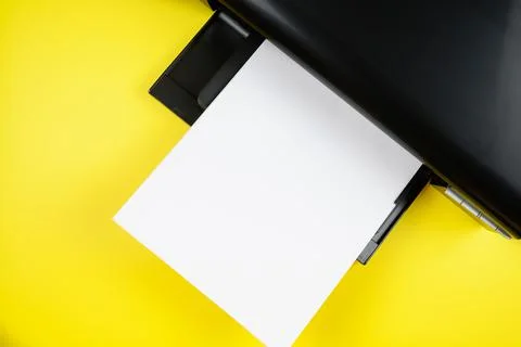 Top view of the printer and a blank sheet of a4 paper on a yellow background Stock Photos