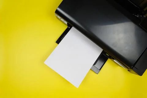 Top view of the printer and a blank sheet of a4 paper on a yellow background Stock Photos